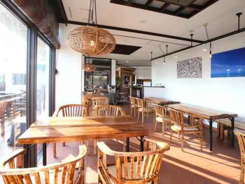 a dining room with wooden tables and chairs at Haruhoo Resort ISHIGAKI in Ishigaki Island