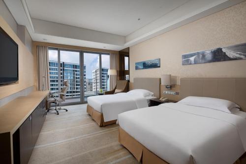 a hotel room with two beds and a television at Crowne Plaza Guangzhou Huadu by IHG - Free Shuttle bus between hotel to Exhibition Center During Canton Fair in Guangzhou