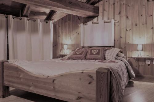 ボンヌヴァル・シュル・アルクにあるBel appartement dans chalet traditionnel à Bonneval sur Arc 84924の木製の壁のベッドルーム1室(大型ベッド1台付)