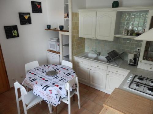 - une cuisine avec une table, des chaises et un évier dans l'établissement Appartement 3 pièces 4 personne centre village - 3 Pièces 4 personnes MAE-7788, à Saintes-Maries-de-la-Mer