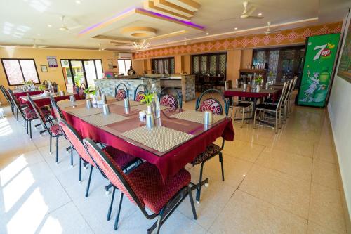 uma sala de jantar com mesas e cadeiras num restaurante em Hotel TamilNadu, Madurai II em Madurai