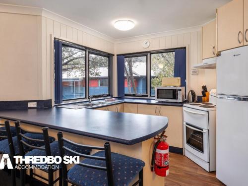 a kitchen with a large counter top and windows at Kirkwood 4 in Thredbo