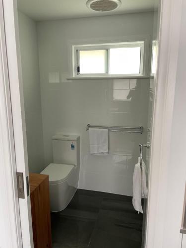 une salle de bain blanche avec toilettes et fenêtre dans l'établissement Robe Nampara Cottages, à Robe