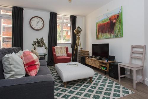 a living room with a couch and a tv at Lovely 2 Bedroom Flat near Whitechapel Station in London