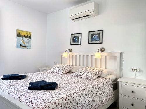 sypialnia z łóżkiem, na którym leżą dwa niebieskie ręczniki w obiekcie Apartamento La Torna Casasol w mieście Nerja