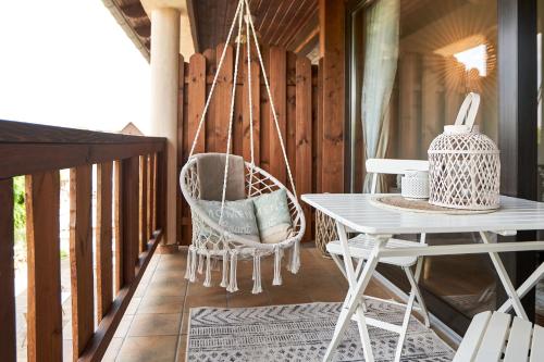 eine Veranda mit einer Hängematte sowie einem Tisch und Stühlen in der Unterkunft Strandhaus Hotel in Parey