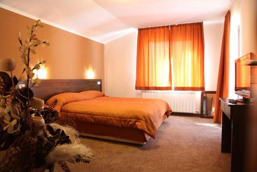 a hotel room with a bed and a window at Двете къщи в планината in Beli Osŭm