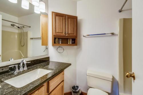 een badkamer met een wastafel, een toilet en een spiegel bij Trail Creek 70 in Killington