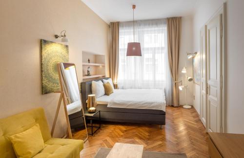 1 dormitorio con cama, sofá y ventana en Mordecai 12 Apartments by Adrez en Praga