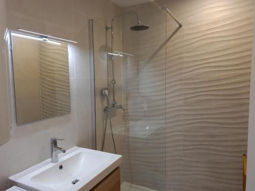 une salle de bain avec un lavabo et une douche en verre dans l'établissement Renovated apartment, air-conditioned 5min from sea, à Saint-Raphaël