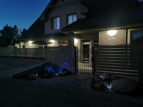 a house lit up at night with a fence at Kalvāni in Mērsrags