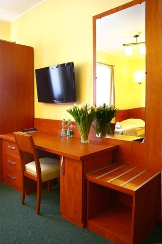 a hotel room with a desk and a mirror at Hotelik & Restauracja Amber in Raszyn