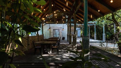 a patio with a wooden table and chairs in a building at Mi Lugar Maldives in Nolhivaranfaru