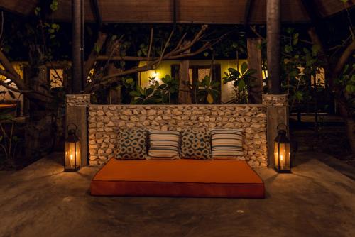 a bed with two pillows and lights in a room at Mi Lugar Maldives in Nolhivaranfaru