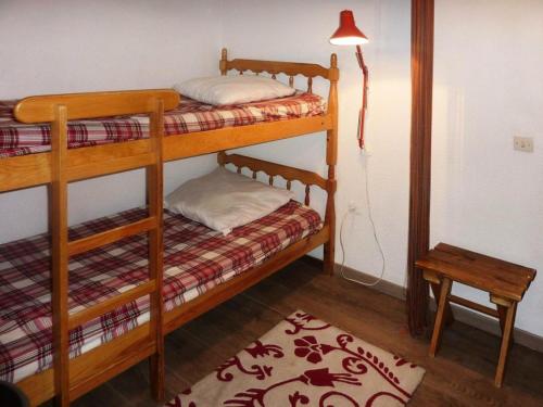 2 lits superposés dans une chambre avec une lampe et un tapis dans l'établissement Résidence Les Gradins - Studio équipé pour 4 personnes MAE-0724, aux Orres