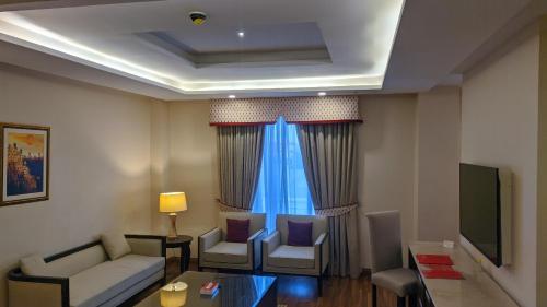 a living room with a couch and a tv at Ramada by Wyndham Lahore Gulberg II in Lahore