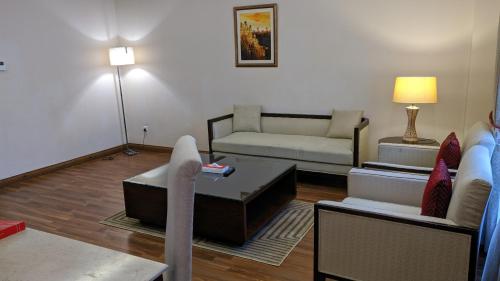 a living room with a couch and a table at Ramada by Wyndham Lahore Gulberg II in Lahore