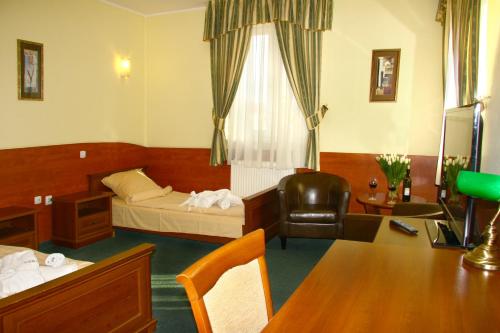 a hotel room with a bed and a desk at Hotelik & Restauracja Amber in Raszyn