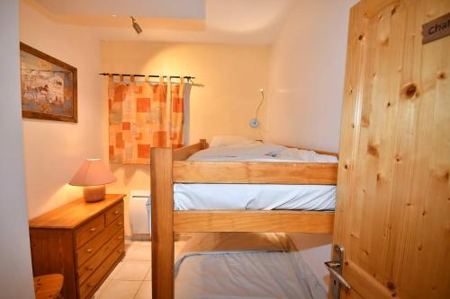 1 dormitorio con litera y puerta de madera en Appartements Le Soleil, en LʼHuez