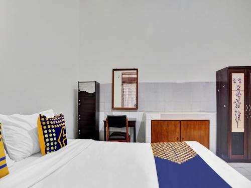 1 dormitorio con 1 cama grande y escritorio en OYO Life 90539 Taman Borobudur Guest House Syariah, en Blimbing
