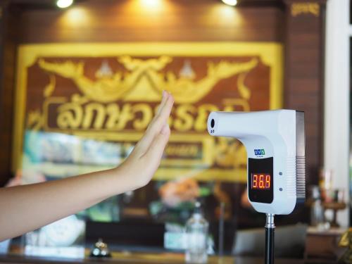 a person is reaching for a scale with their hand at Luckswan Resort Chiang Rai - SHA Extra Plus in Chiang Rai
