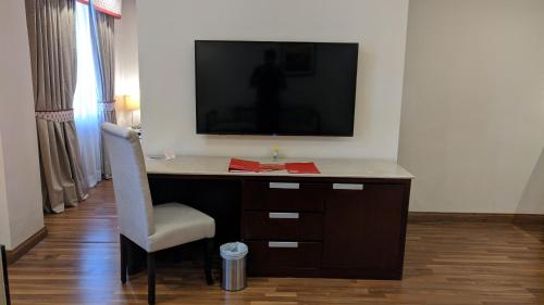 a desk with a television and a chair in a room at Ramada by Wyndham Lahore Gulberg II in Lahore