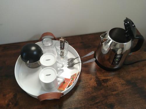 a plate with a tea pot and a kettle on a table at Chambre cosy calme proche aéroport, Groupama Stadium, CNPE BUGEY, Eurexpo in Chavanoz