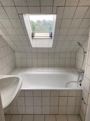 a white bath tub in a bathroom with a window at NO SMOKE Ferienwohnung Schwalbe in Hagen