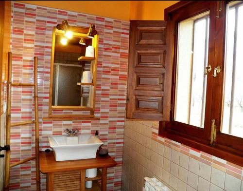 een badkamer met een wastafel en een spiegel bij CASA RURAL MOLINO DEL JERTE in Navaconcejo