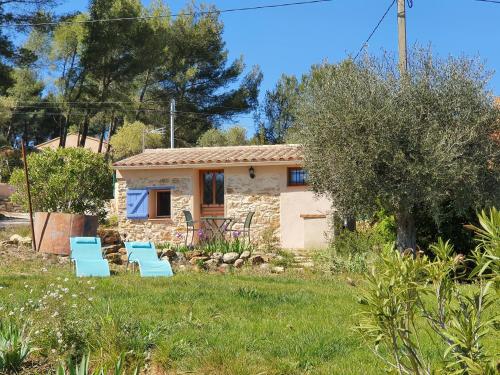 a stone cottage with blue chairs in the yard at cabanon studio in Le Beausset