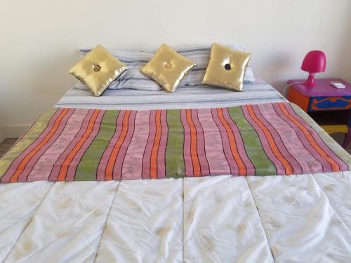 a bed with yellow pillows and a striped blanket at La Plage in Cagnes-sur-Mer