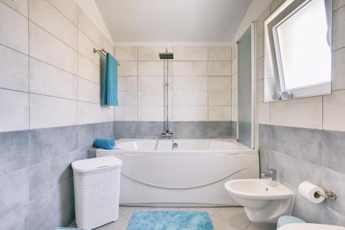 a white bathroom with a tub and a toilet at Holiday house Vedrana, Jadreški in Pula