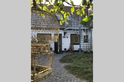 a bird cage in front of a house at AppleFlower Farm retro apartment in Lillerød