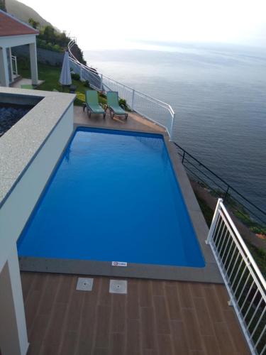 a swimming pool on a balcony next to the ocean at CASA SOL E VISTA 2 in Arco da Calheta