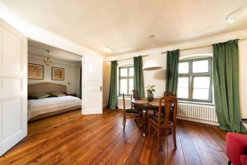 Un dormitorio con una mesa de comedor y una cama. en Old Town Prosta Toruń, en Toruń