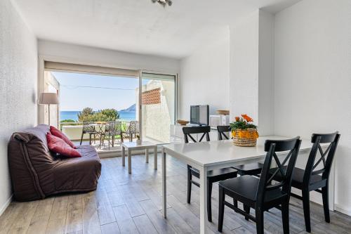 a living room with a table and chairs and a couch at Appartement vue plage avec terrasse et wifi in La Seyne-sur-Mer