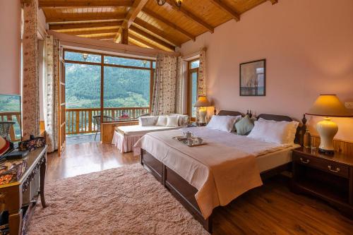 a bedroom with two beds and a large window at StayVista at The Wisteria House - Luxurious home with Lavish Interiors in Manāli