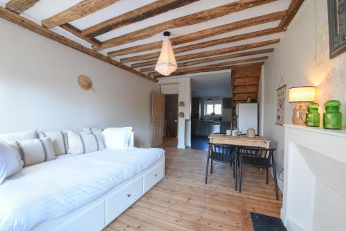 une chambre avec un lit et une table avec des chaises dans l'établissement Les Nids Perchés - Place Notre-Dame, à Mortagne-au-Perche
