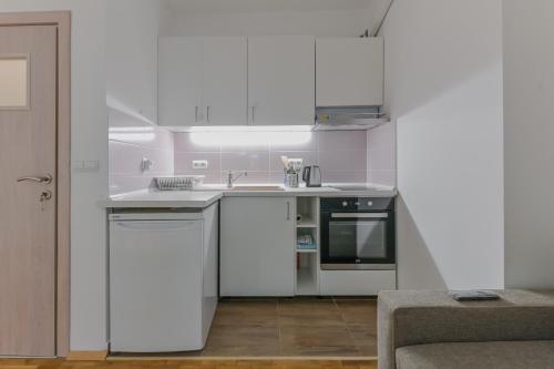 una cucina bianca con lavello e fornello di Bright Apartment in the Heart of the City by Flat Mаnager a Sofia