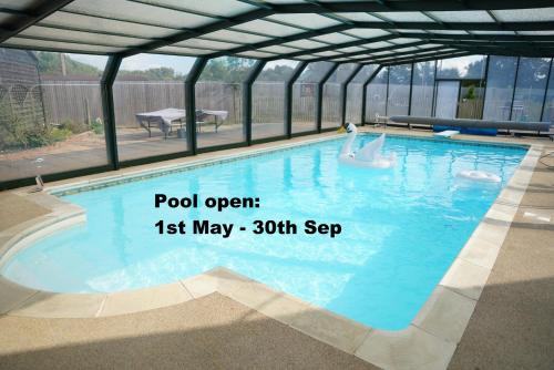 a swimming pool in a building with the words pool open may at The Piggery Pod in Sittingbourne