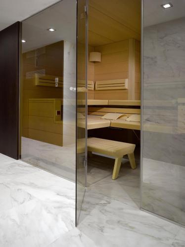 a glass wall in a room with a bed and a bench at Old Town Square Residence by Emblem in Prague