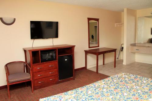 a hotel room with a bed and a television on a dresser at Best Way Inn and Suites - New Orleans in New Orleans