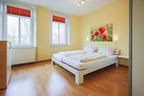 SahrensdorfにあるFerienhof Büdlfarm - Bauers Hausのベッドルーム1室(壁に絵画が描かれたベッド1台付)