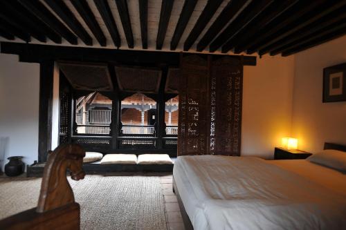 a bedroom with a bed and a large window at Peacock Guest House in Bhaktapur
