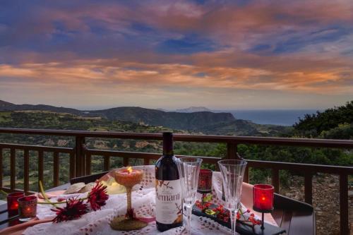 a bottle of wine sitting on a table on a balcony at Welcoming villa in Triopetra with pool in Triopetra