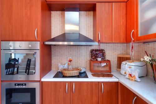 a kitchen with wooden cabinets and a stove top oven at Welcoming villa in Triopetra with pool in Triopetra