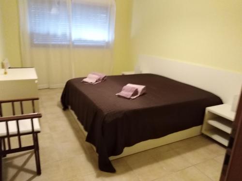 a bedroom with a bed with two pink towels on it at Alto dos Navegantes in Armação de Pêra