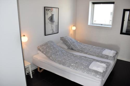 2 łóżka w małym pokoju z oknem w obiekcie Kerteminde Byferie - Hyrdevej 83 - 85J w mieście Kerteminde