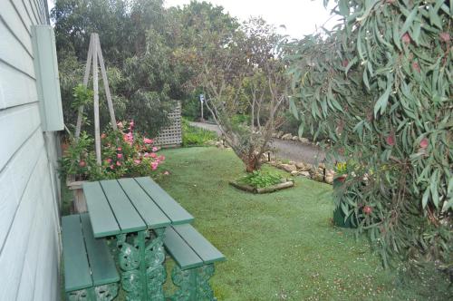 
a green lawn with a lawn chair and some plants at The Fig Tree B&B in Baudin Beach

