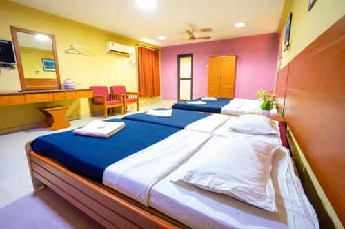 two beds in a hotel room with a mirror at Hotel TamilNadu - Madurai I in Madurai